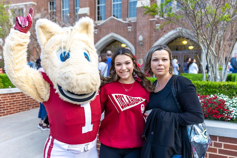 A picture of the OU mascot, Boomer, with a new student and her mother.