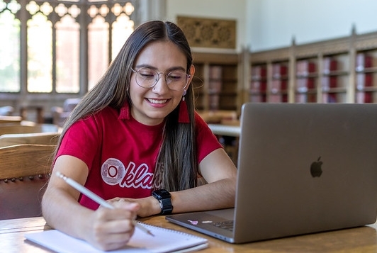 An OU student studying on her laptop in the Great Room inside the Bizzell Memorial Library.