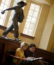 two students studying near the the seed sower statue