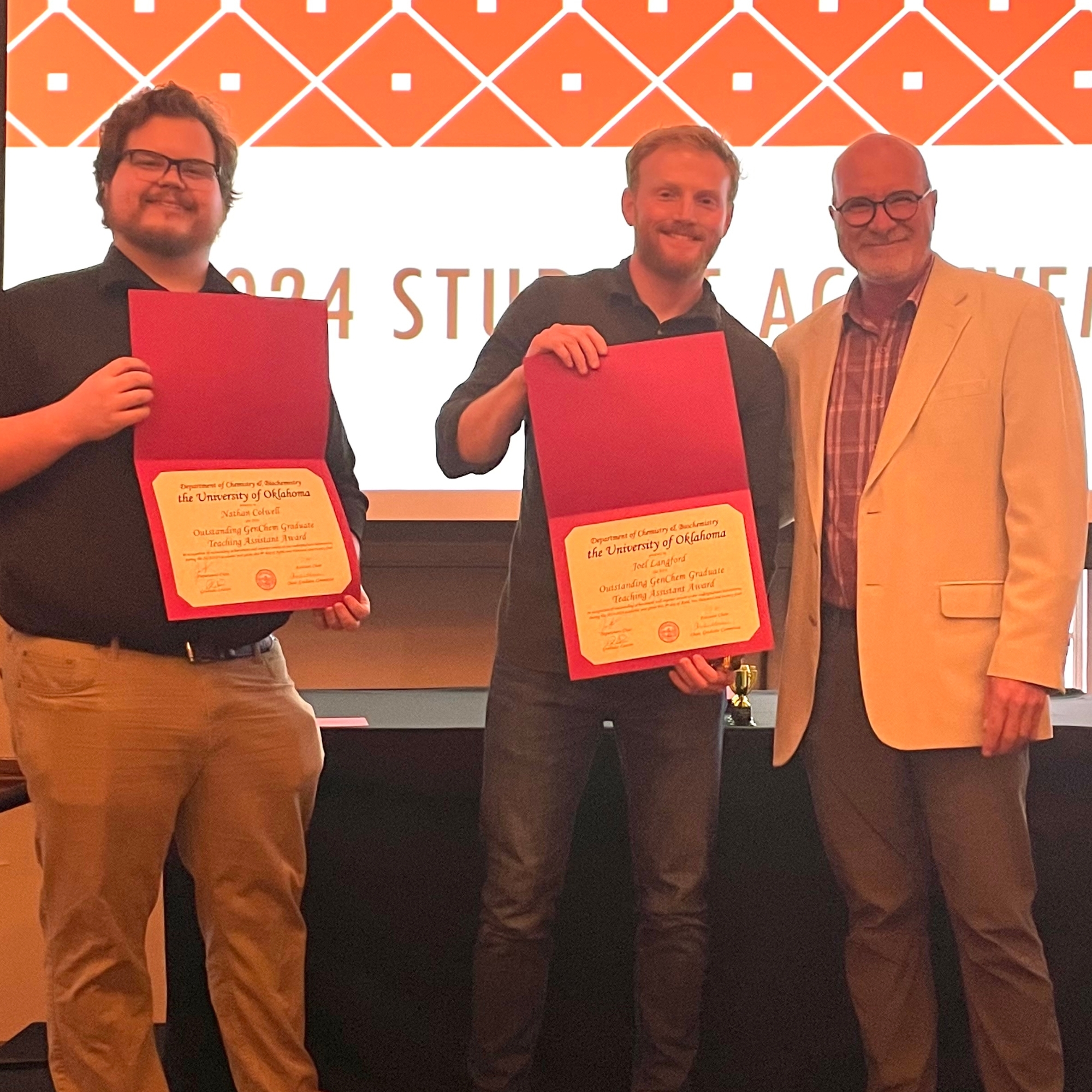 Nathan Colwell and Joel Langford holding awards with Dr. John Peters