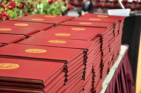 Diplomas stacked on a table.