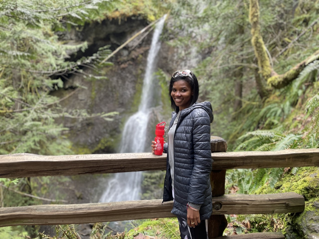 Dolly Na-Yemeh stands in front of a waterfall.