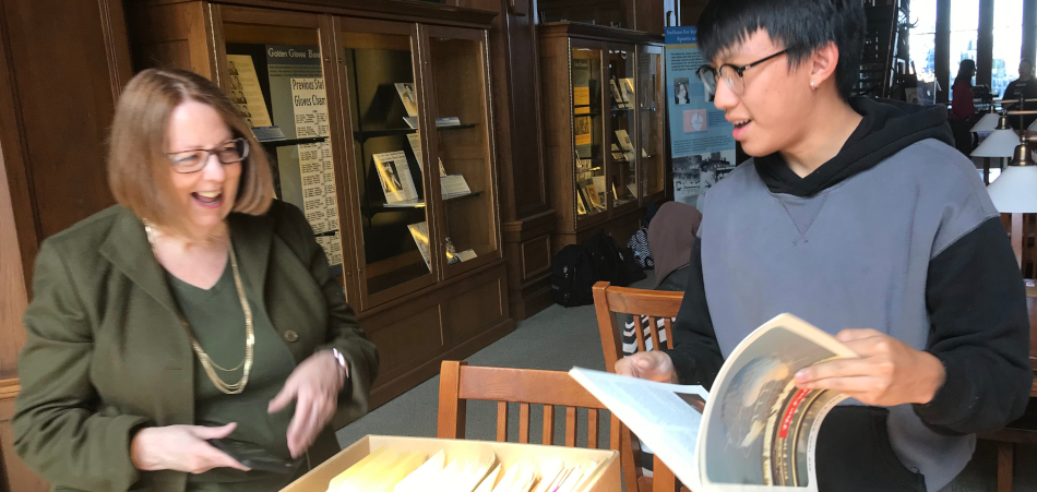 Photo of Professor Pandora talking with a student in the Western History Collections.