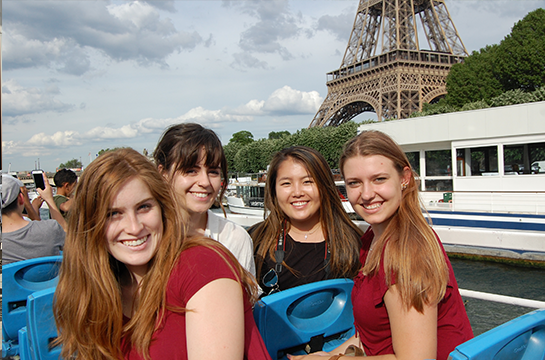 Students traveling in boat in Paris, France.