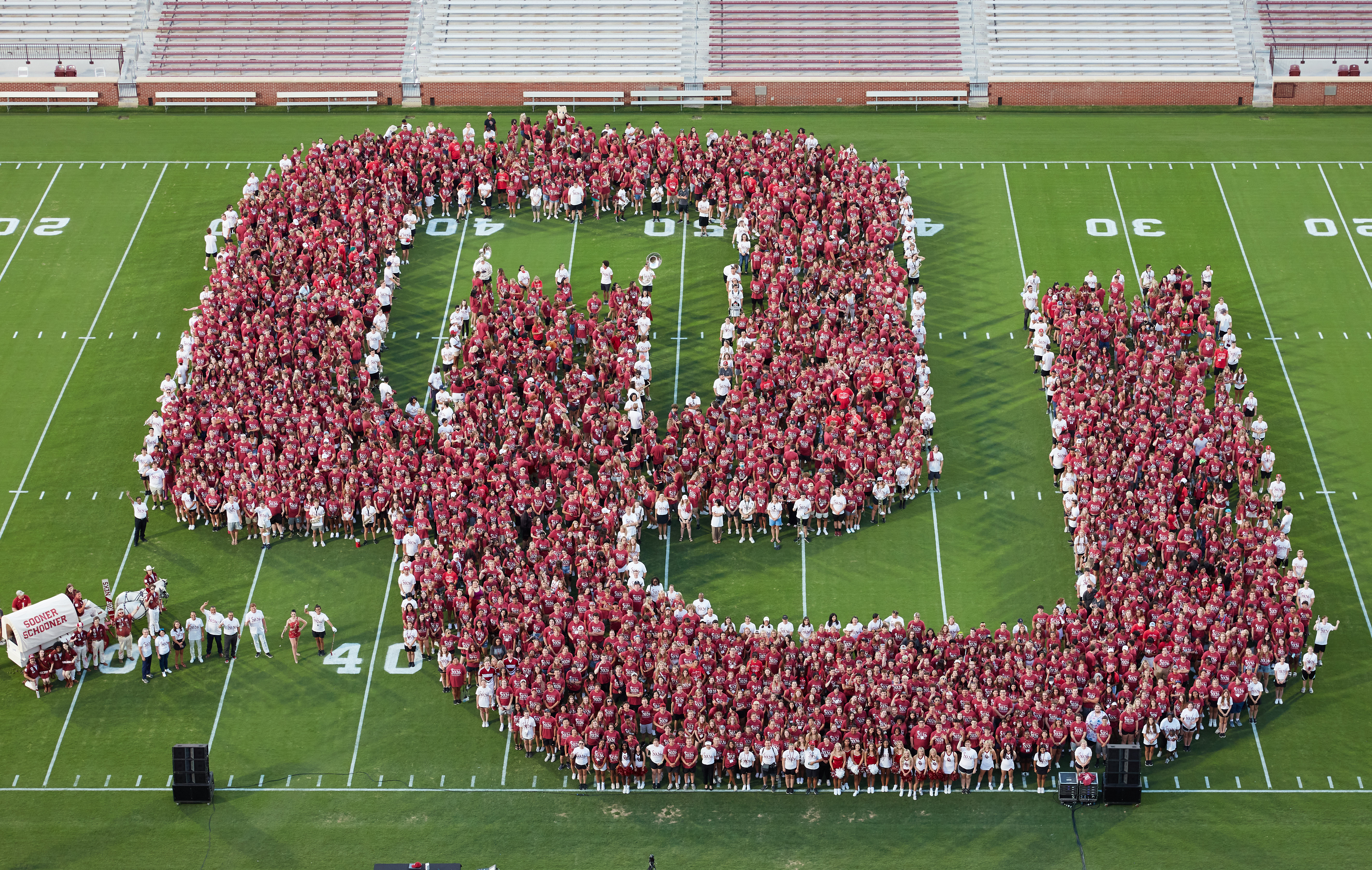 newly enrolled students on the football field lined up to create the OU logo