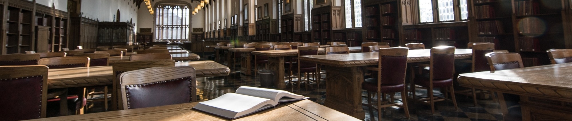 An open book lies on a table in the Great Reading Room in Bizzell Memorial Library.