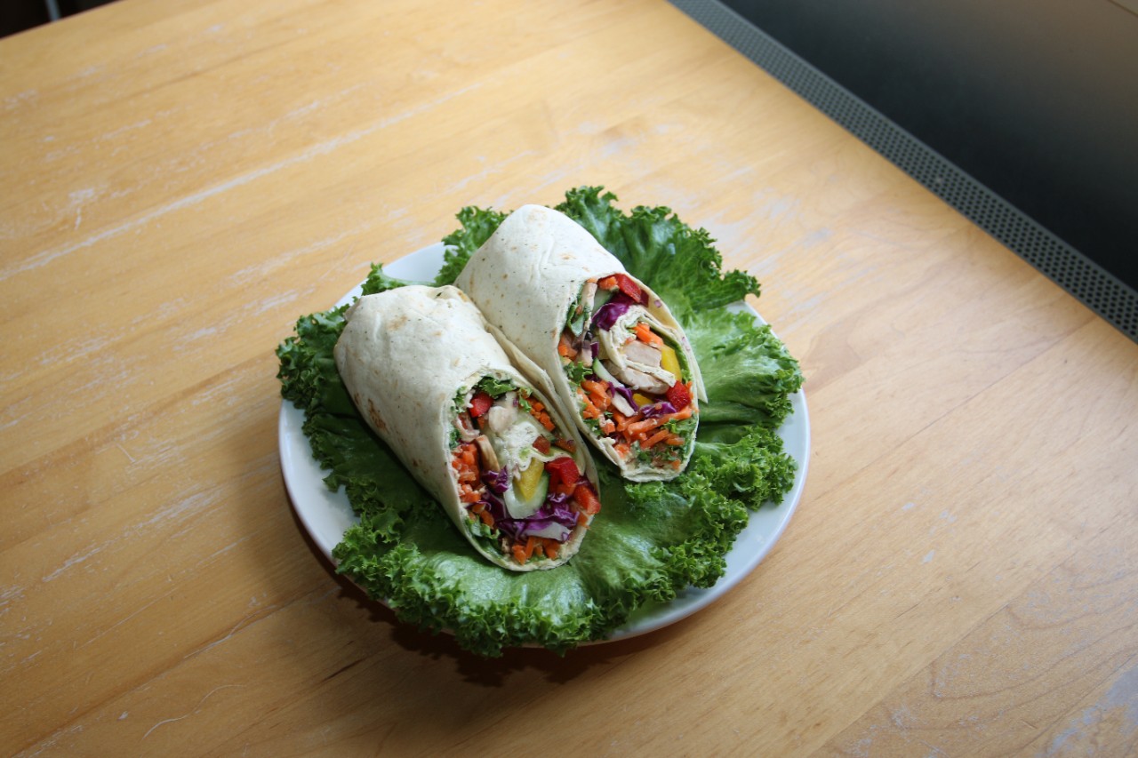 vegan wraps plated on a bed of lettuce on tabletop