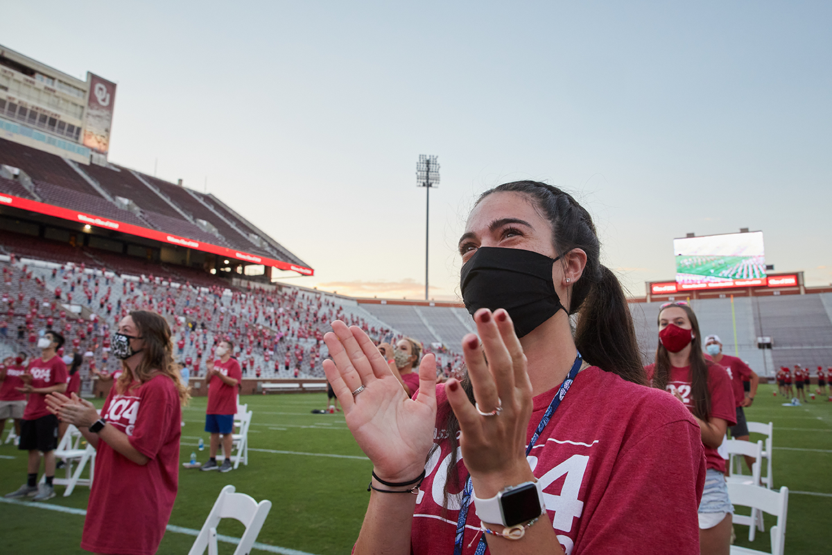 a masked student claps at the class kickoff event