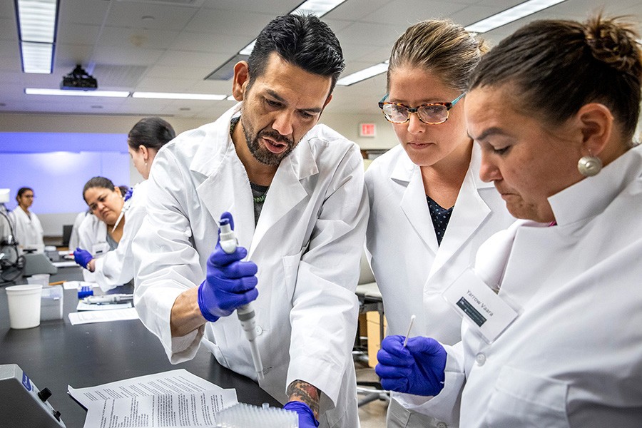 Justin Lund, Dr. Jessica Blanchard and Yarrow Vaara practice a DNA extraction protocol at a conference for Native students interested in genomics.