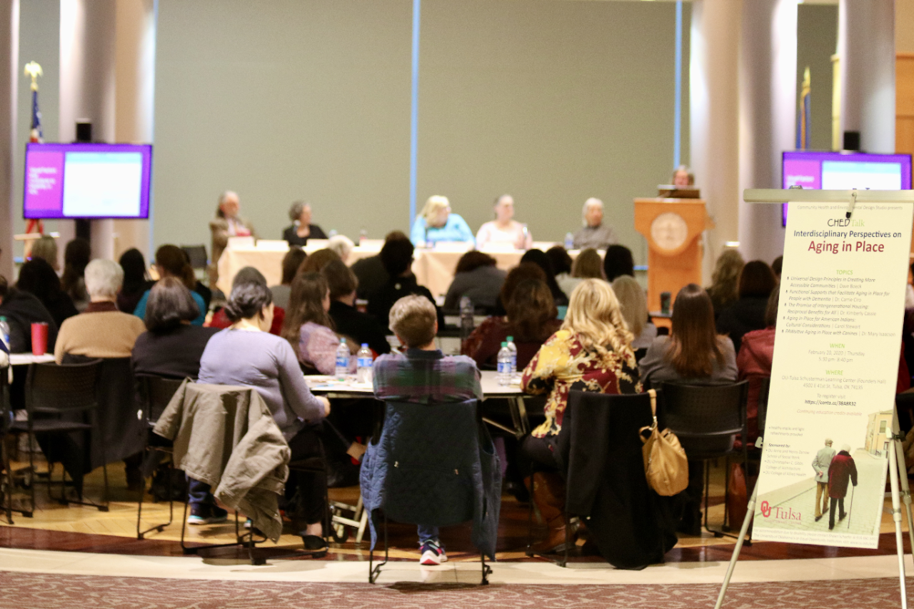 Lecturers speak to a seated audience at an Aging in Place event. 
