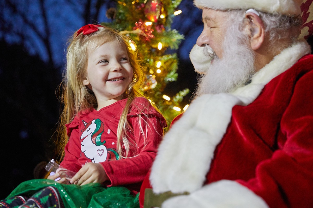 Young girl sits on Santa's lap
