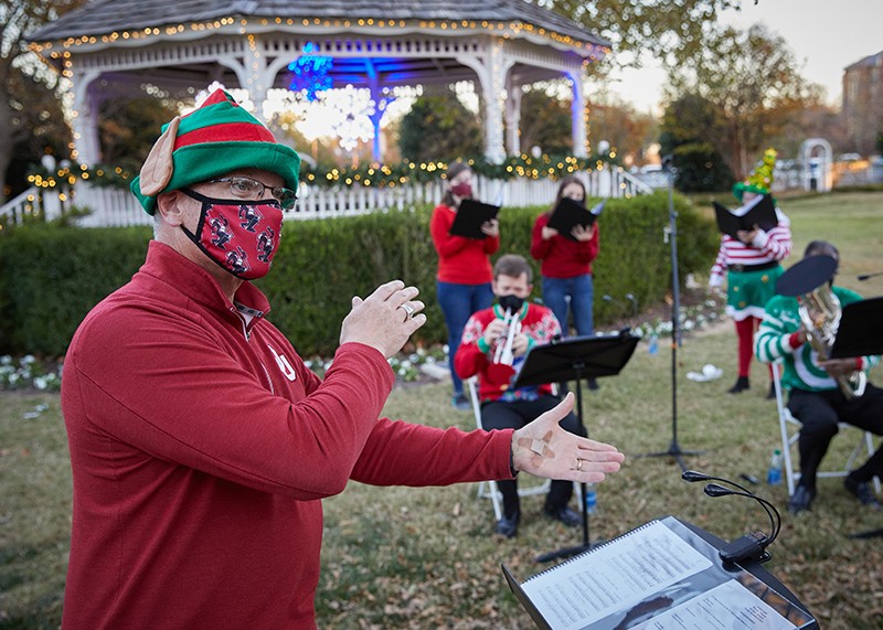 Members of the OU marching band play and sing while wearring masks