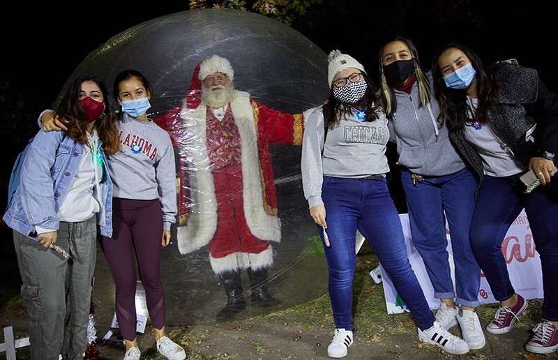 santa poses with more students from inside a protective bubble