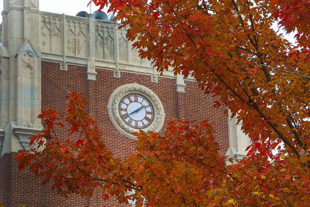 OMU clock tower framed by fall leaves