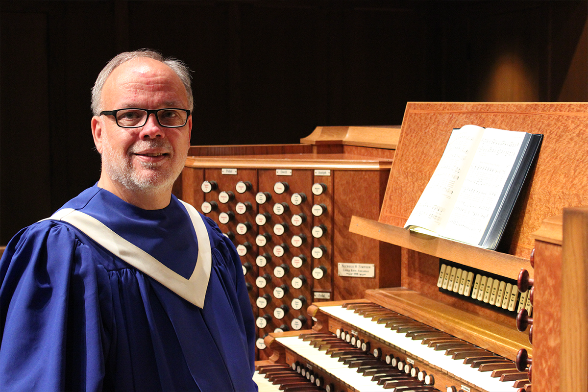 James Maase poses in regalia next to organ