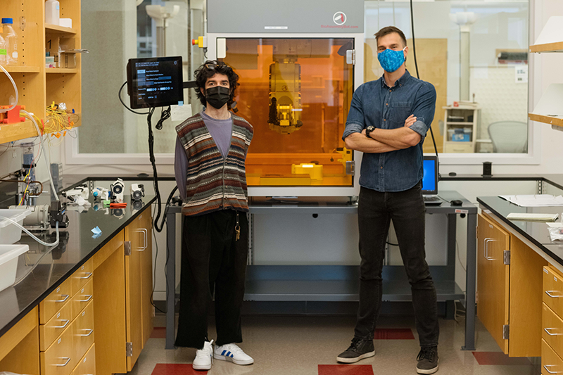 Ali Rassi and his adviser, ISE assistant professor Pedro Huebner, stand in front of the BioAssemblyBot