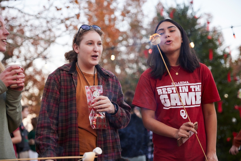 Two members of the OU Community chat and roast marshmallows