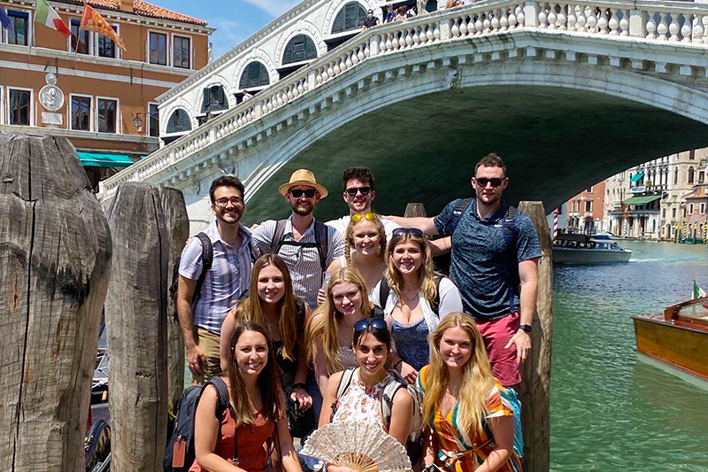 Group of students posed near bridge in Venice
