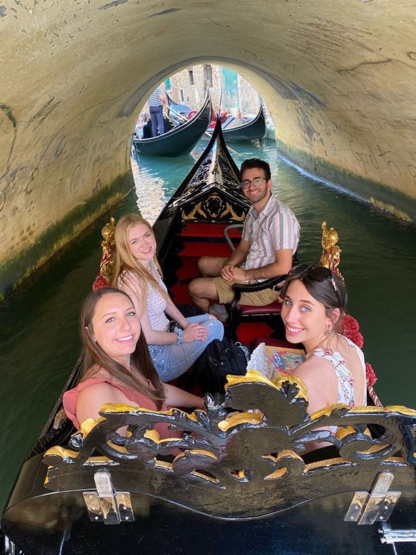 students posed together sitting on a Gondola