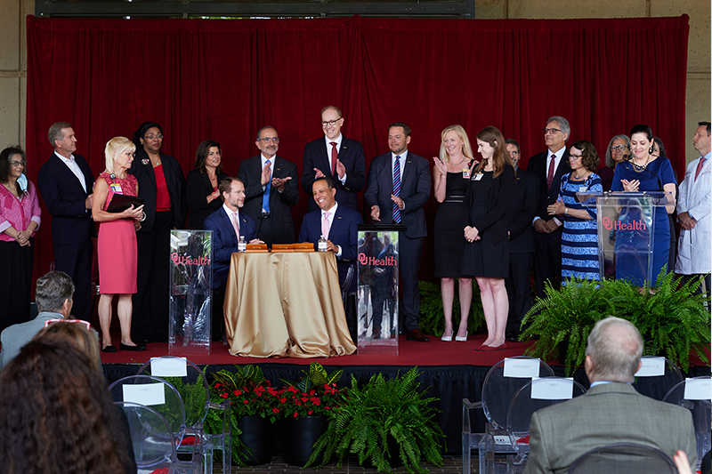 Image from OU Health event: stage full of individuals (including President Harroz seated at table) 