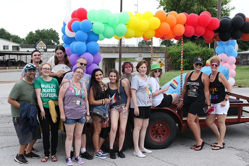 Group posed in front of Pride Parade float