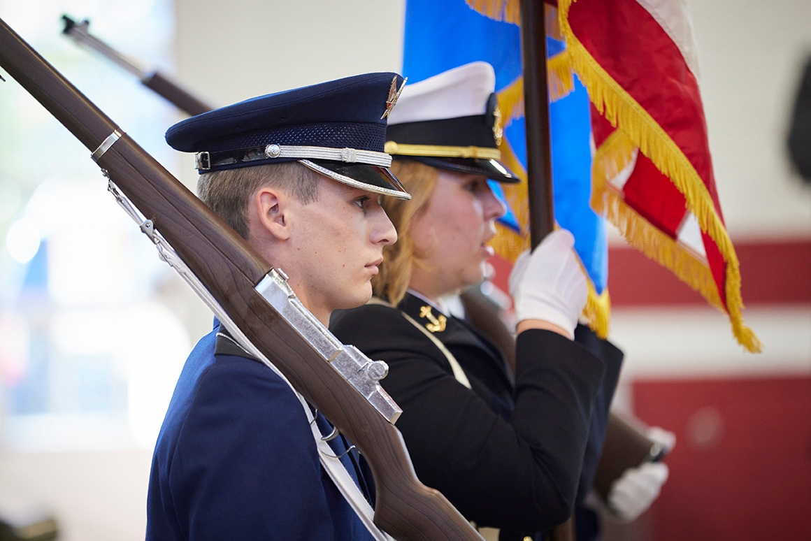 Cadets pose with flags and rifles