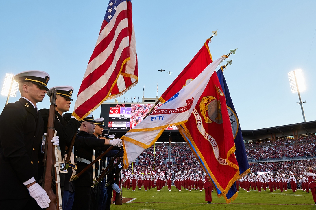ROTC members pose with flags at the football game