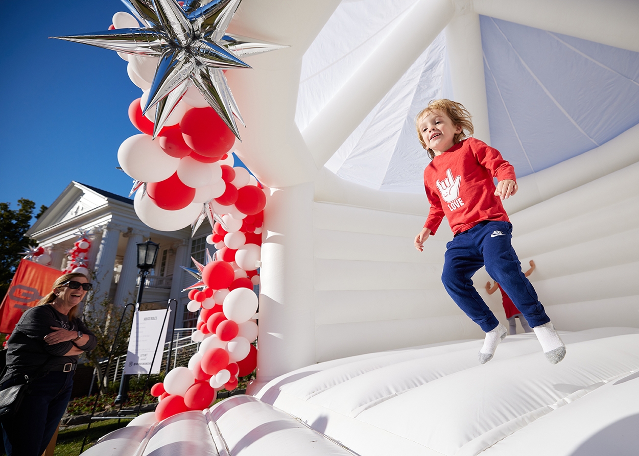 A child jumps in an inflatable bounce house at the Boyd House Block party