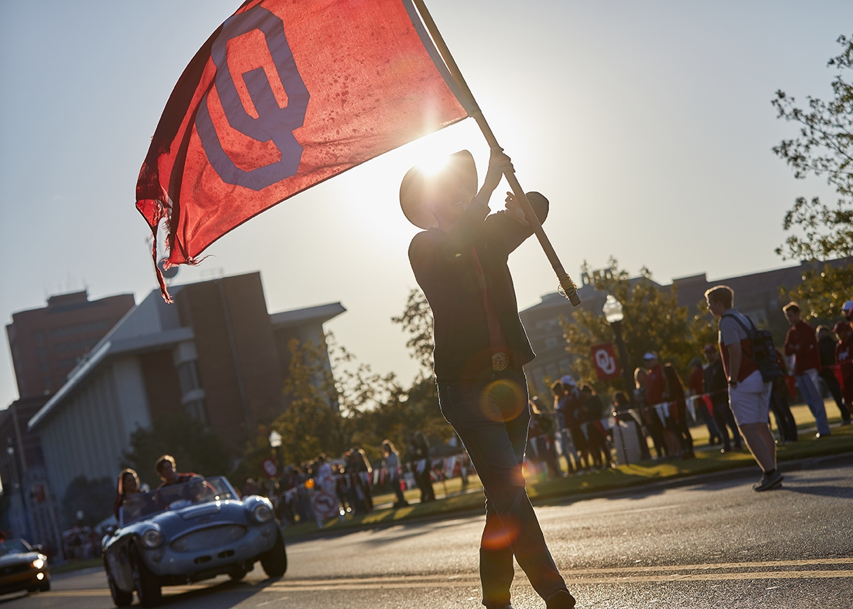 Student holds an OU flag aloft during the parade