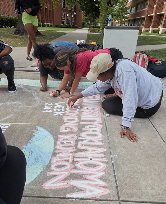 Students chalk the sidewalk for Chalk the Walk