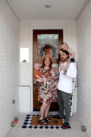 family poses for photo in doorway