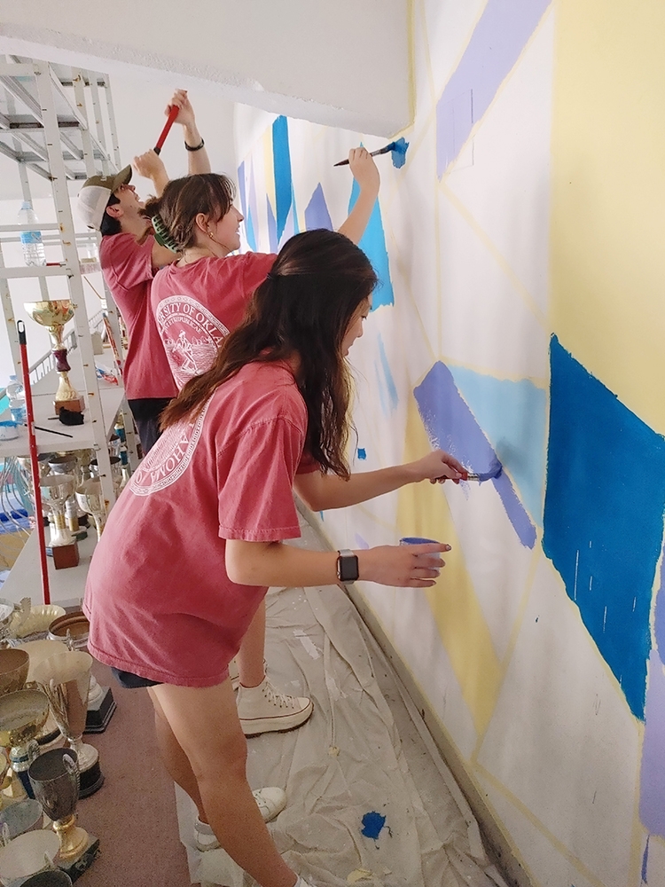 students fill in another section of the mural