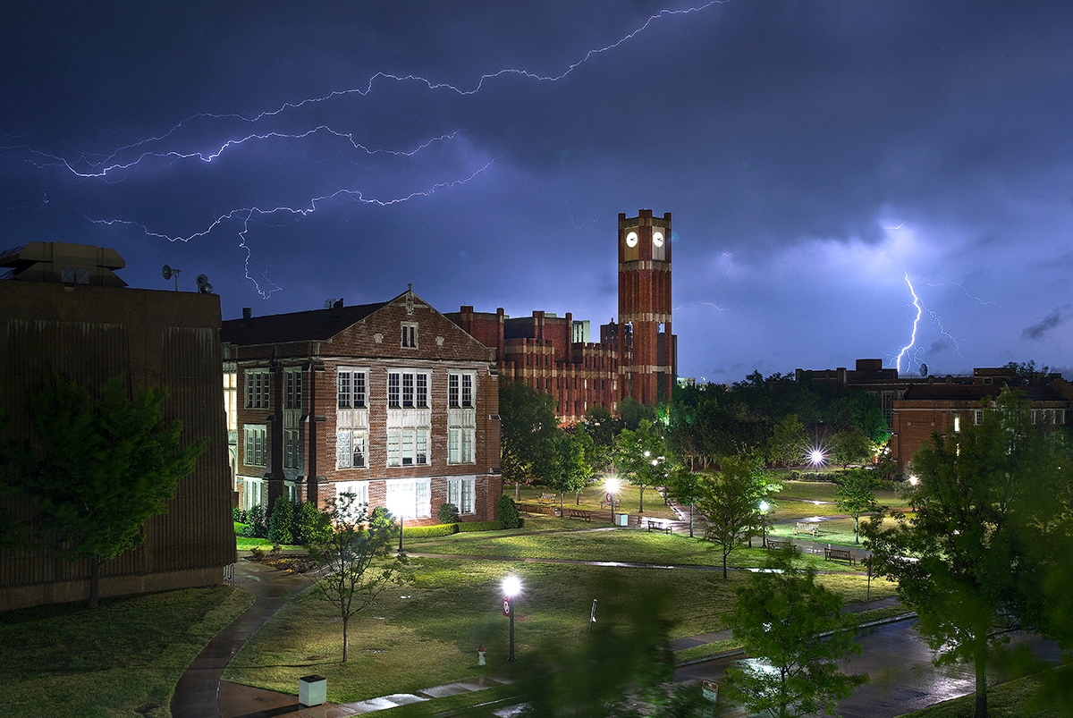 Photo of a gray sky and lightening over Sutton Hall at OU