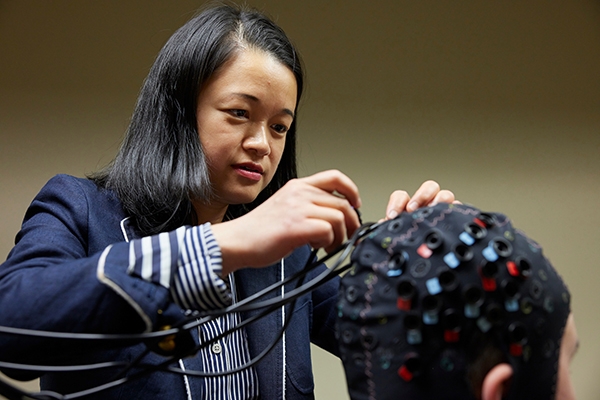 Han Yuan adjusts sensors on a cap