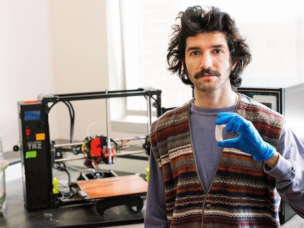OU alumnus and former graduate student Ali Rassi holds his design of a 3D printed implant designed to treat TMJ in the jaw.