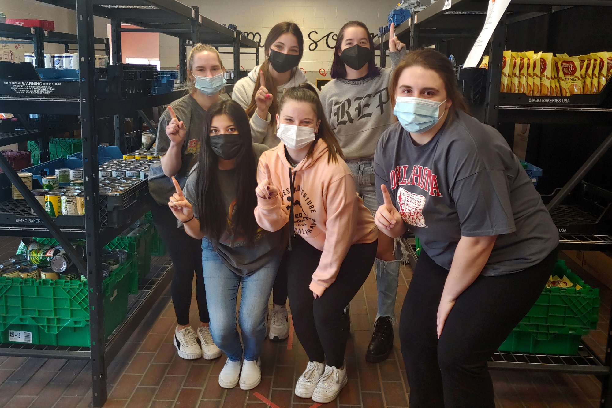 Masked student workers pose at the pantry
