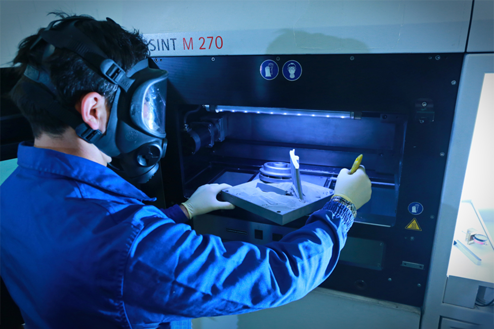 worker in a safety mask interacts with the printer