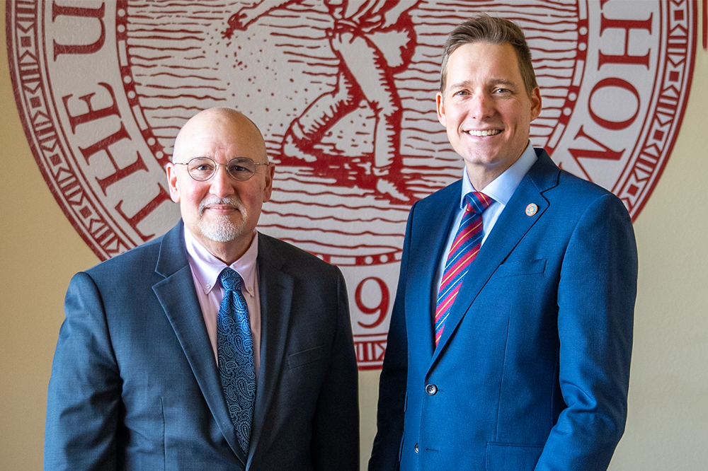 portrait of Sluss and Pinnell in front of OU Seal