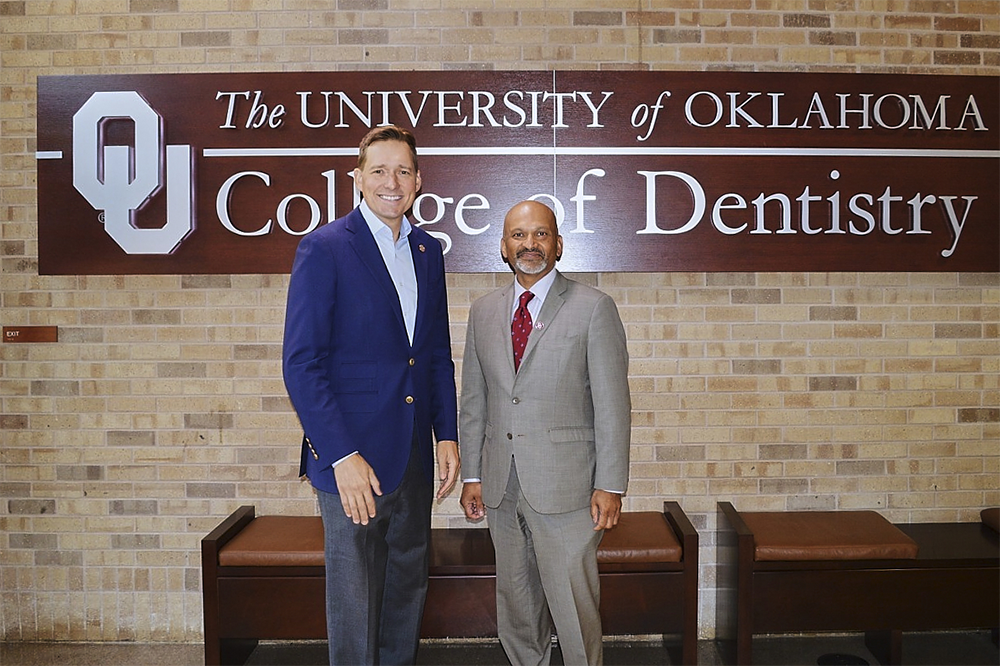 Pinnell and Mullasseril pose in front of the College of Dentistry sign