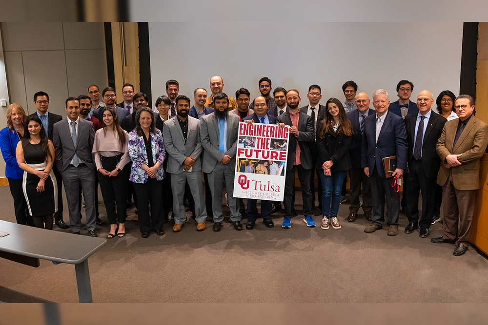 group of students and faculty pose for a photo holding a poster