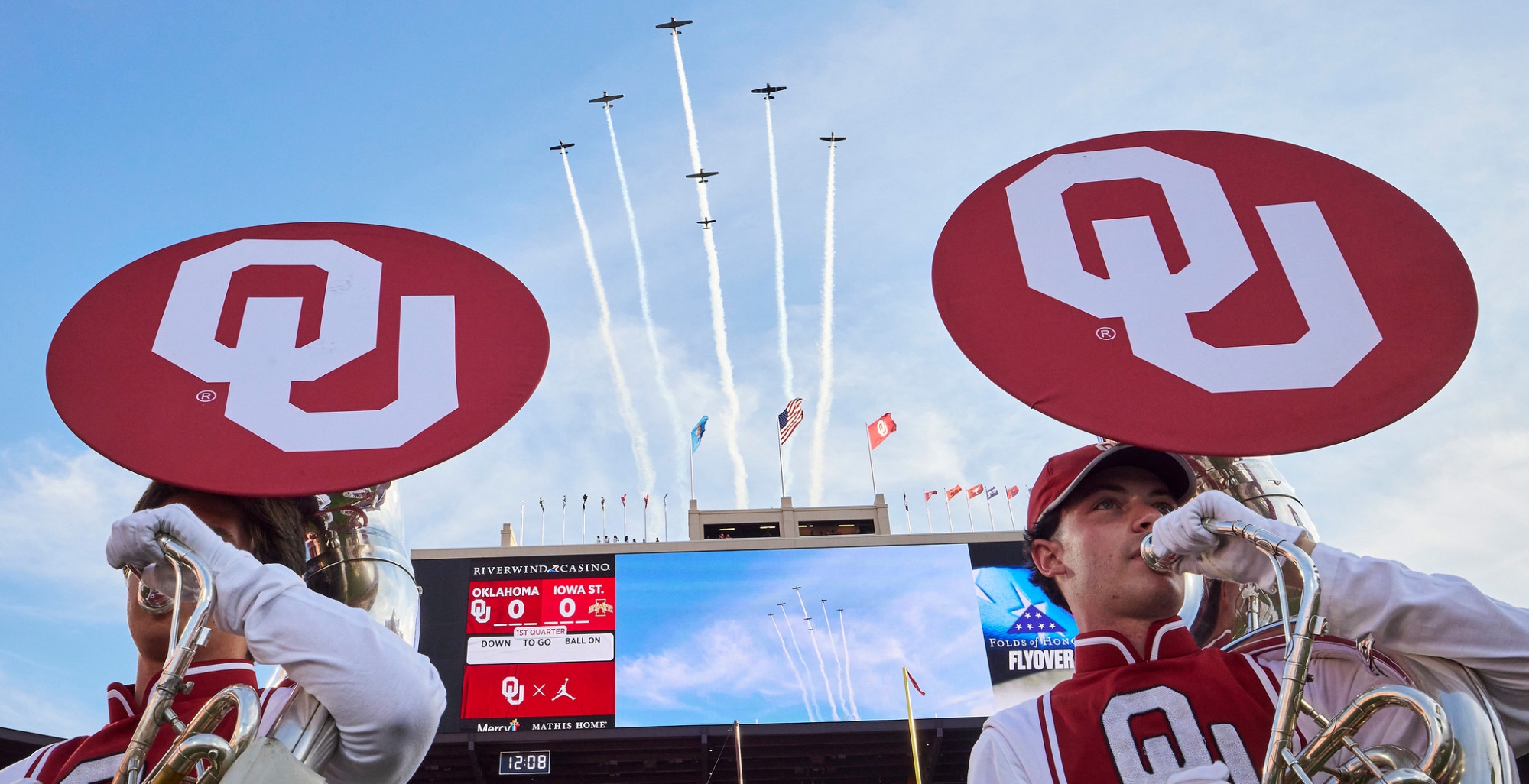 Two OU Pride members with flyover during an OU football game