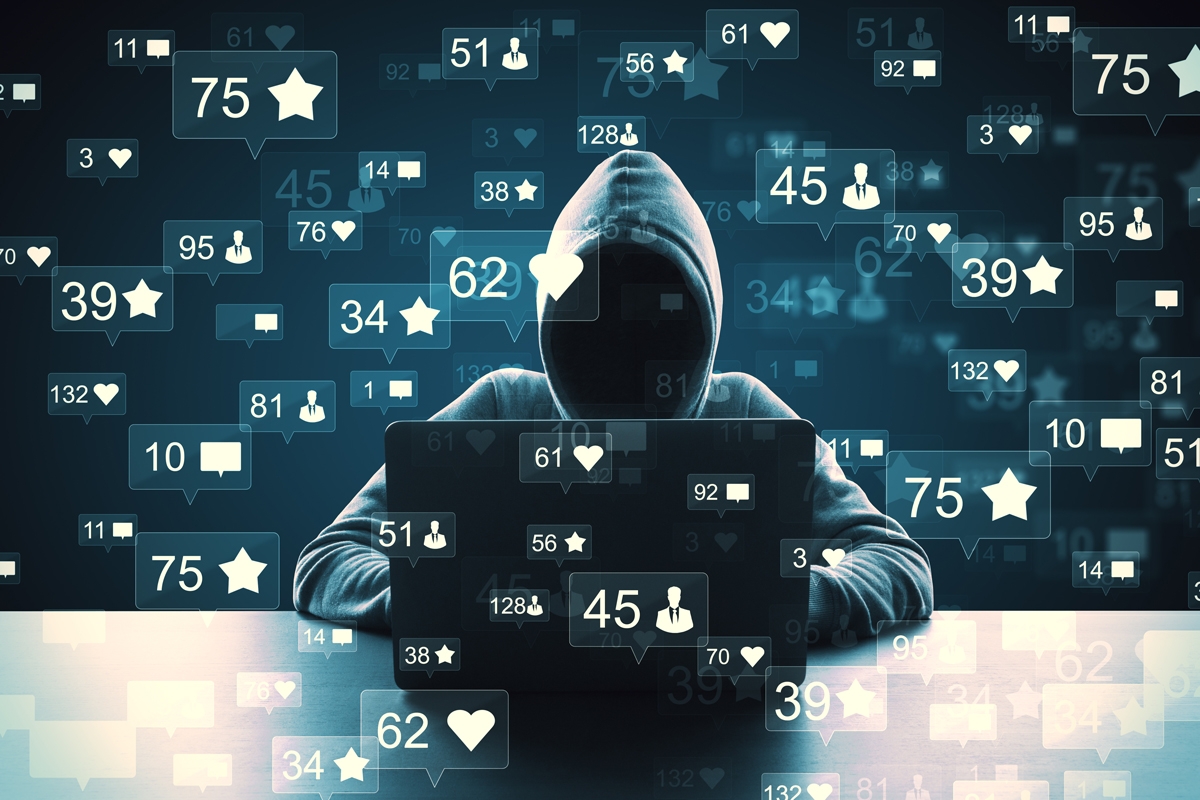 stock image of hooded man at computer