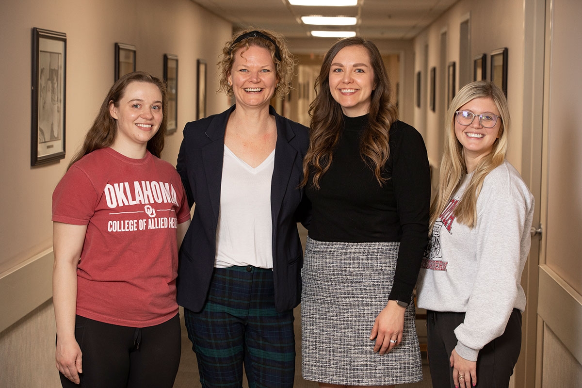 Health-PAL contributors Heather De, Nicole Colvin, and Kiernin Lewis post for a photo with Dr. Klinedinst at OU-Tulsa