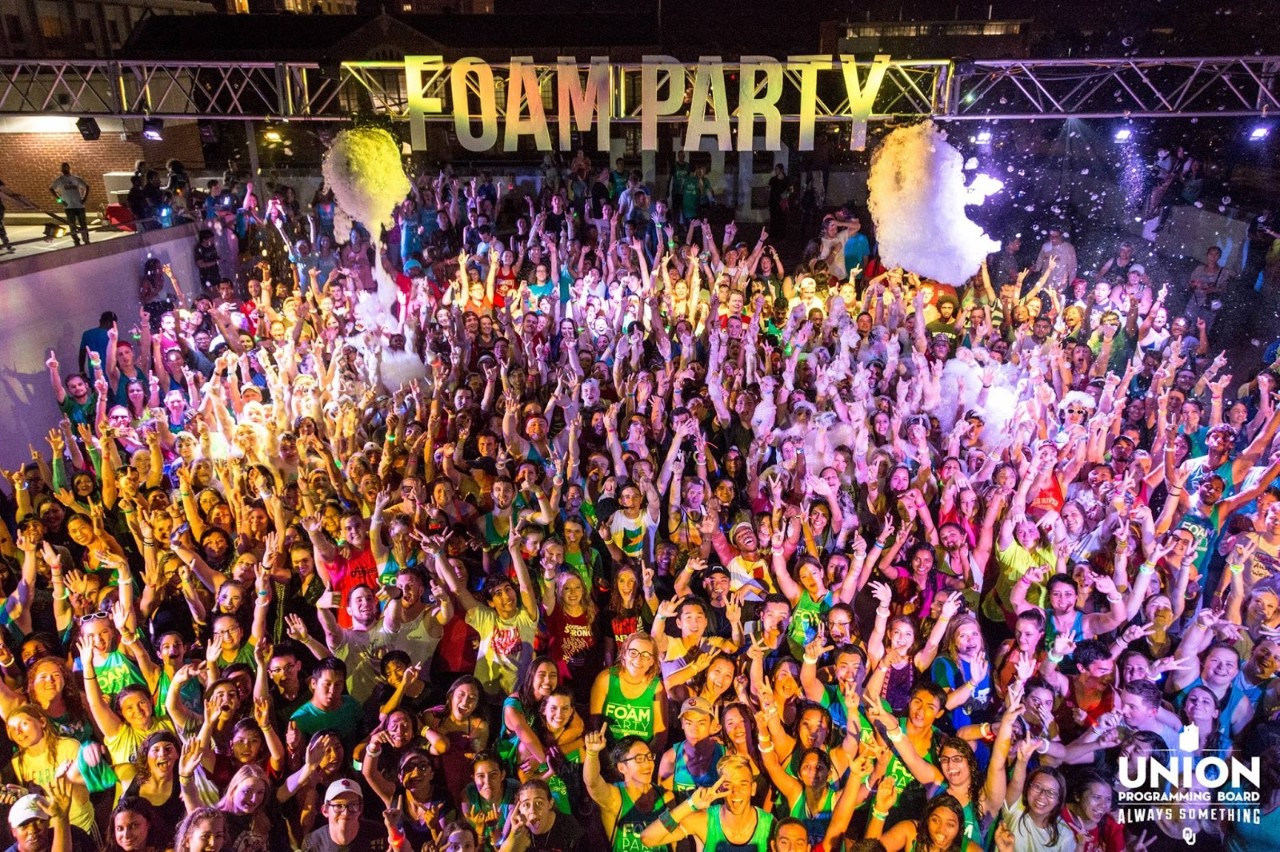 This image features previous foam party attendees smiling and looking at the camera.