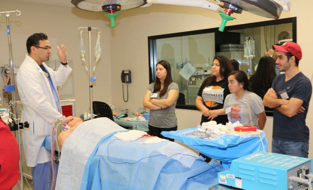 students watching a doctor demonstrate in an operation room.