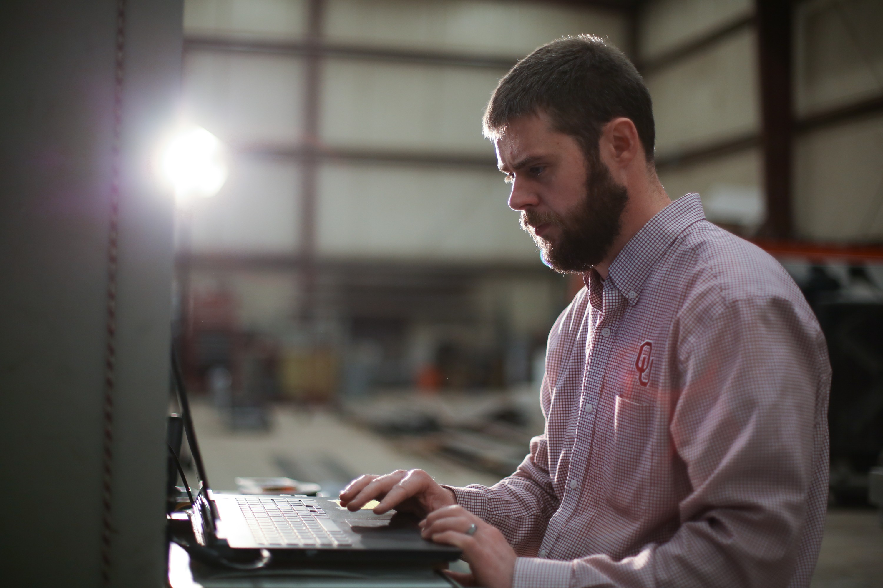 An OU Engineer at Fears Lab works on his laptop.
