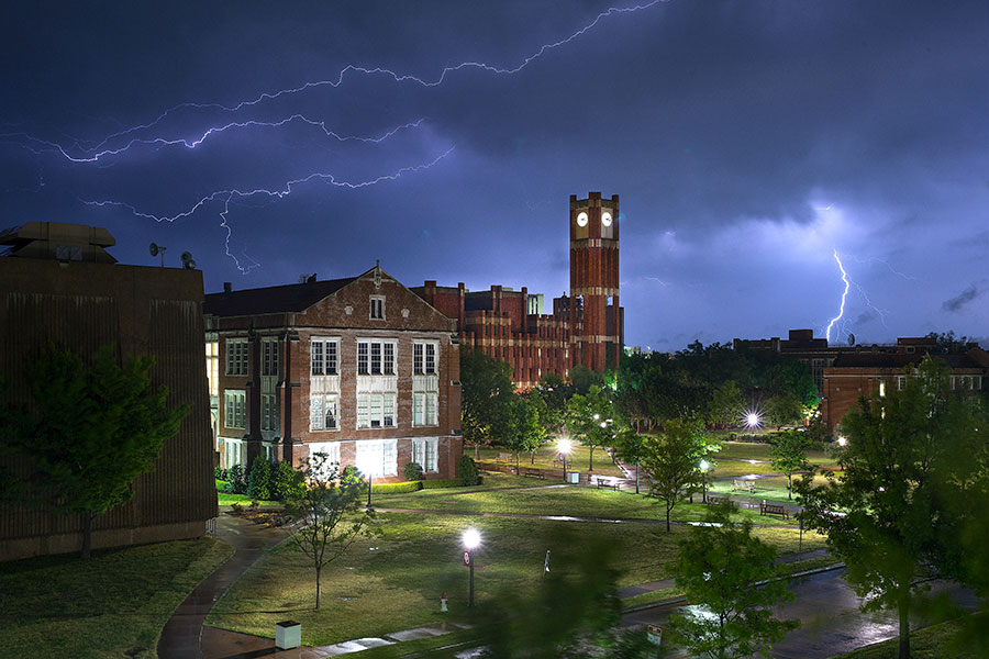 Lightning illuminates the sky behind the University of Oklahoma Bizzel Library.
