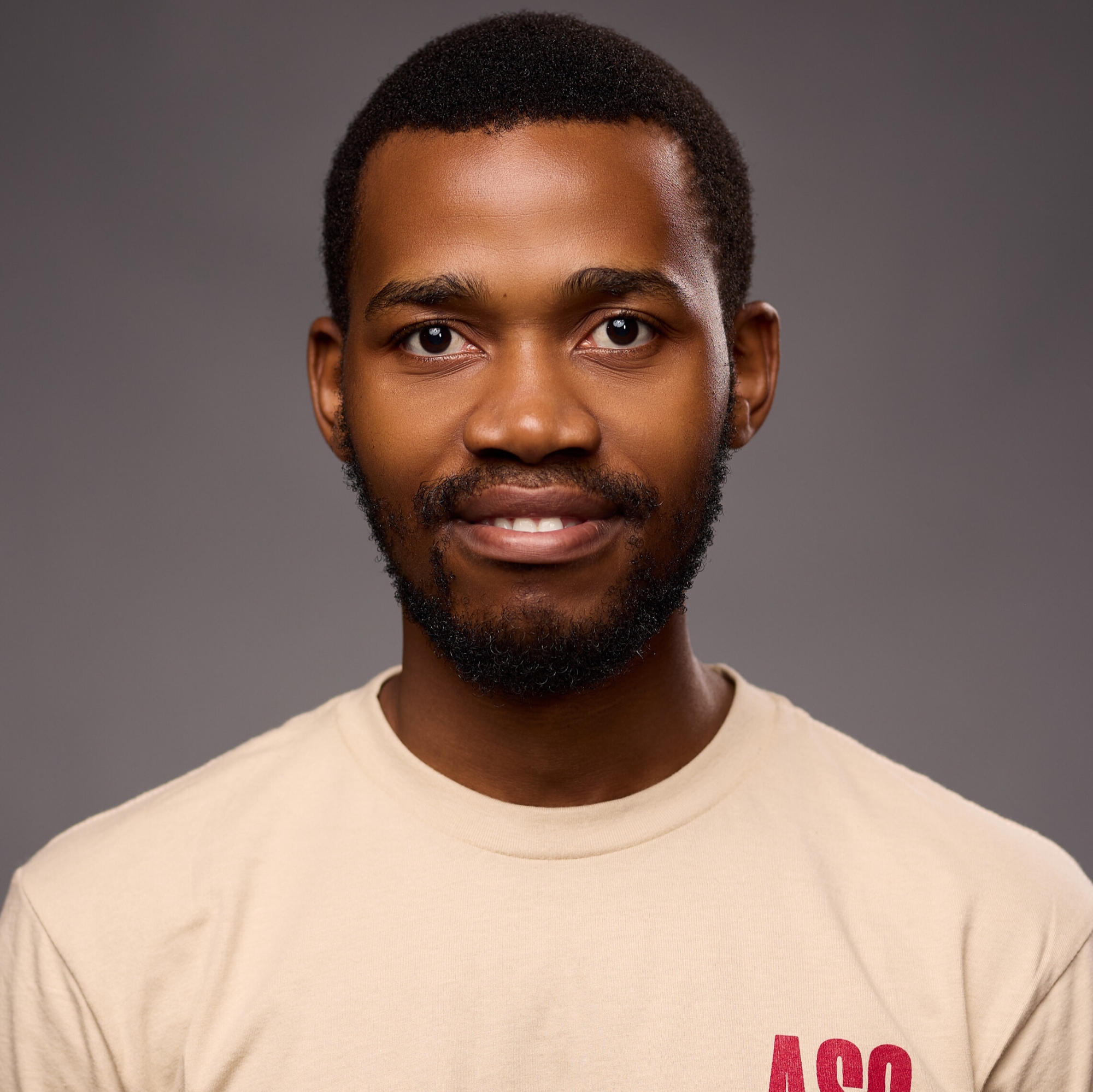An O U flag on a lamppost, surrounded by greenery.