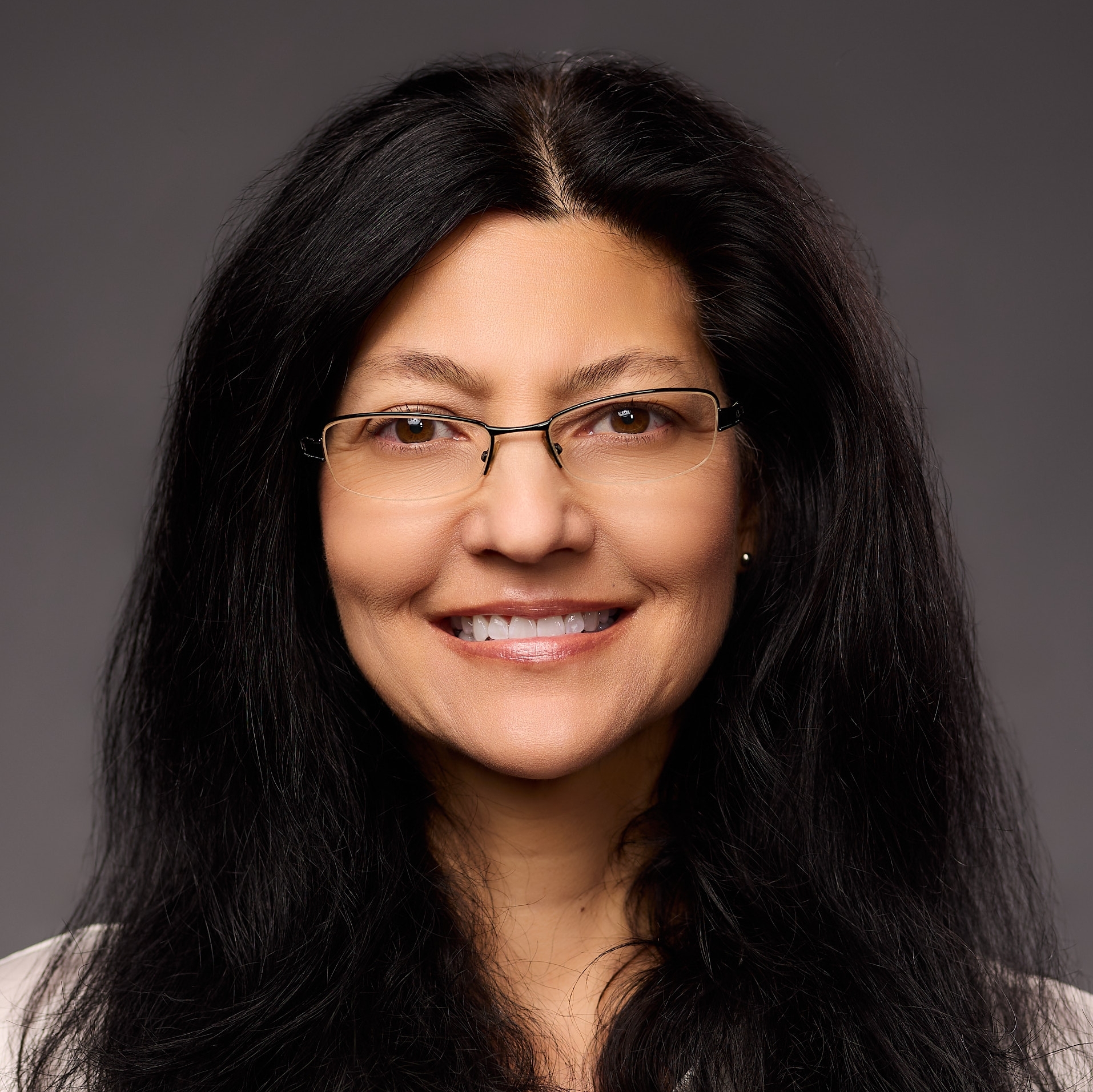 An O U flag on a lamppost, surrounded by greenery.