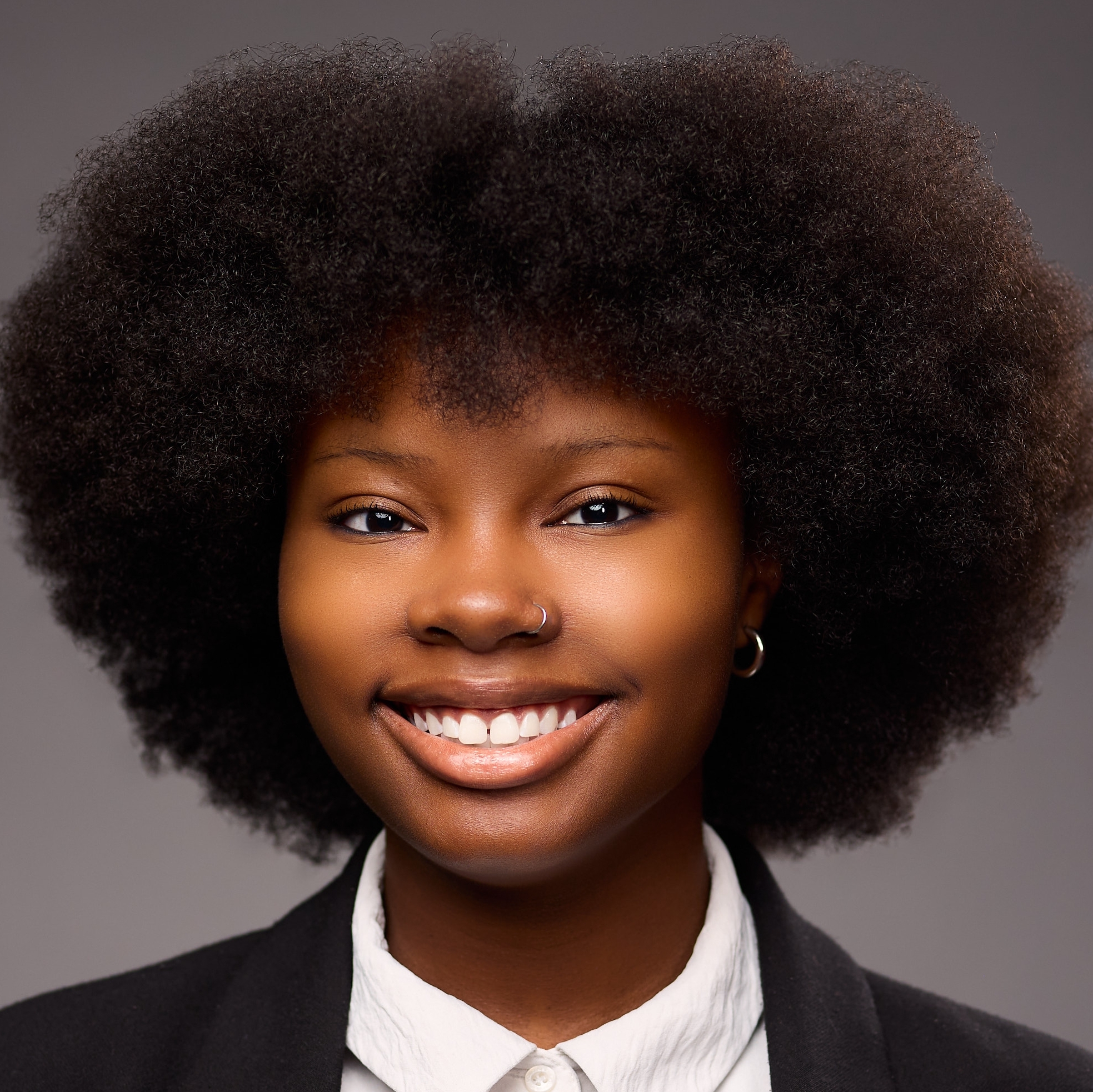 An O U flag on a lamppost, surrounded by greenery.